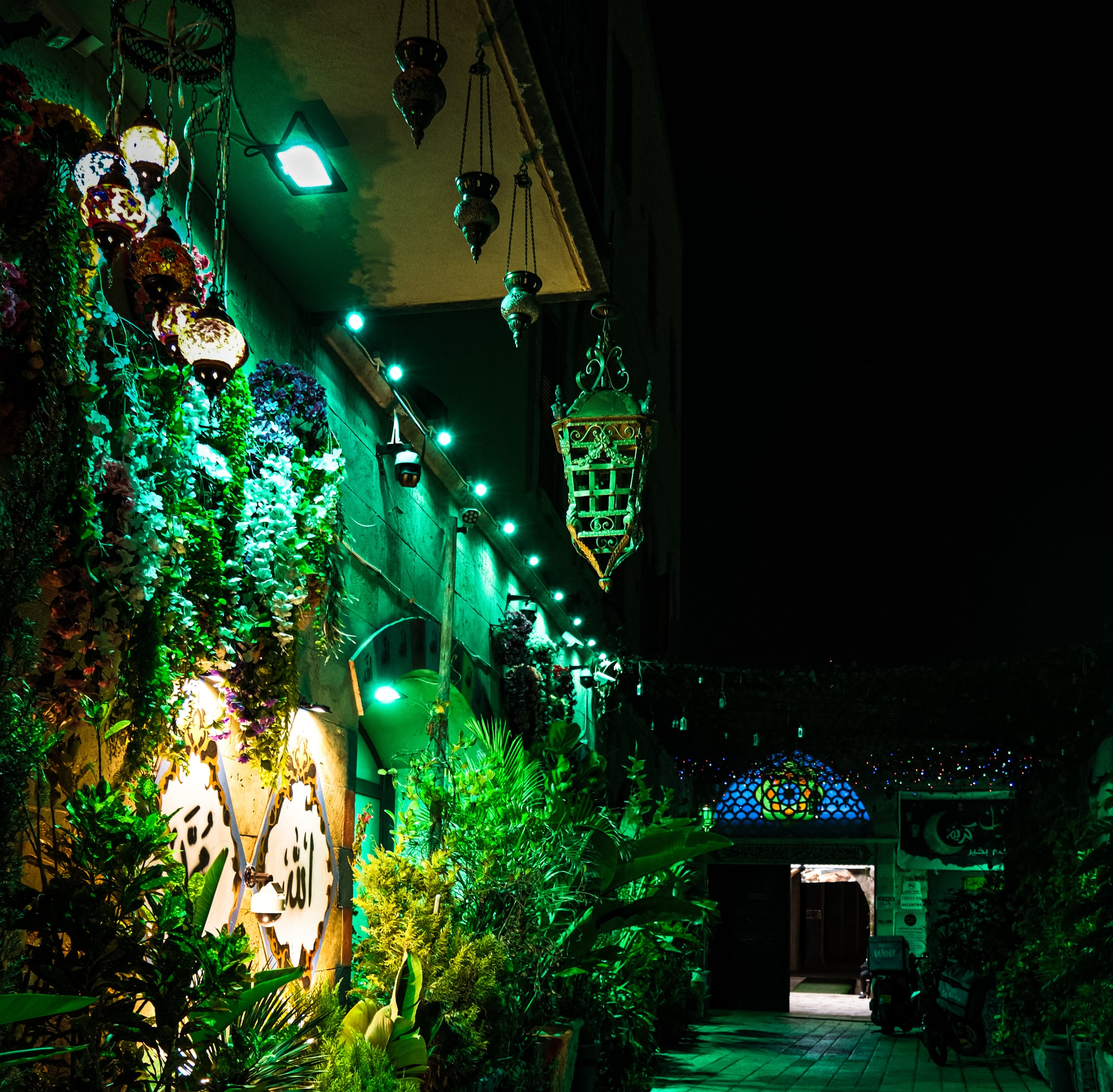 Night street with Middle Eastern market and green neon lanterns