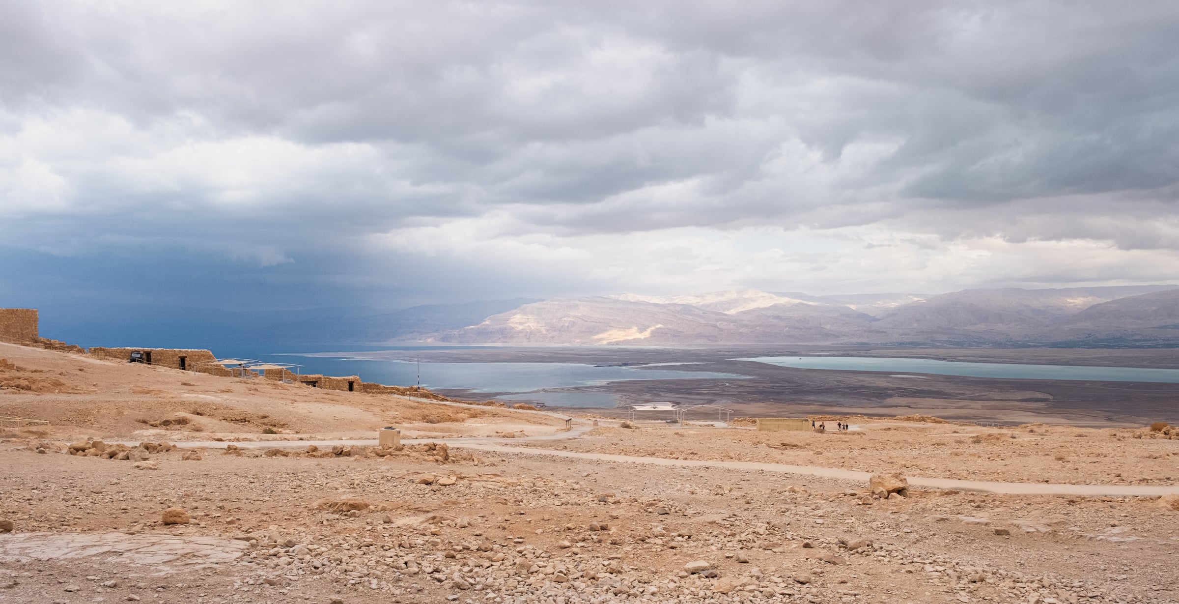 View from Masada fortress over Dead Sea and Jordanian mountains with dramatic storm clouds