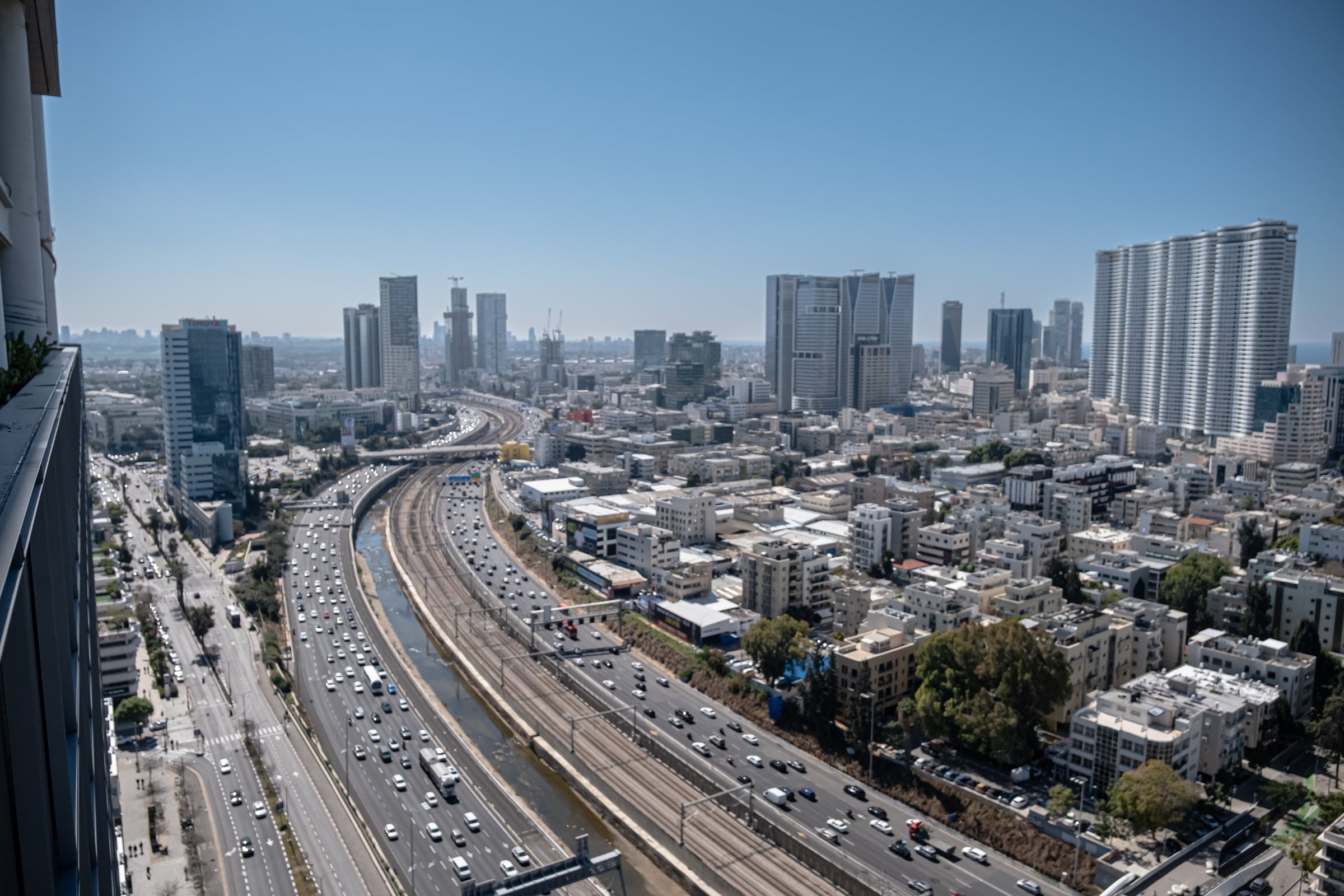 Aerial view of Ayalon Highway in Tel Aviv with heavy traffic and rail tracks alongside