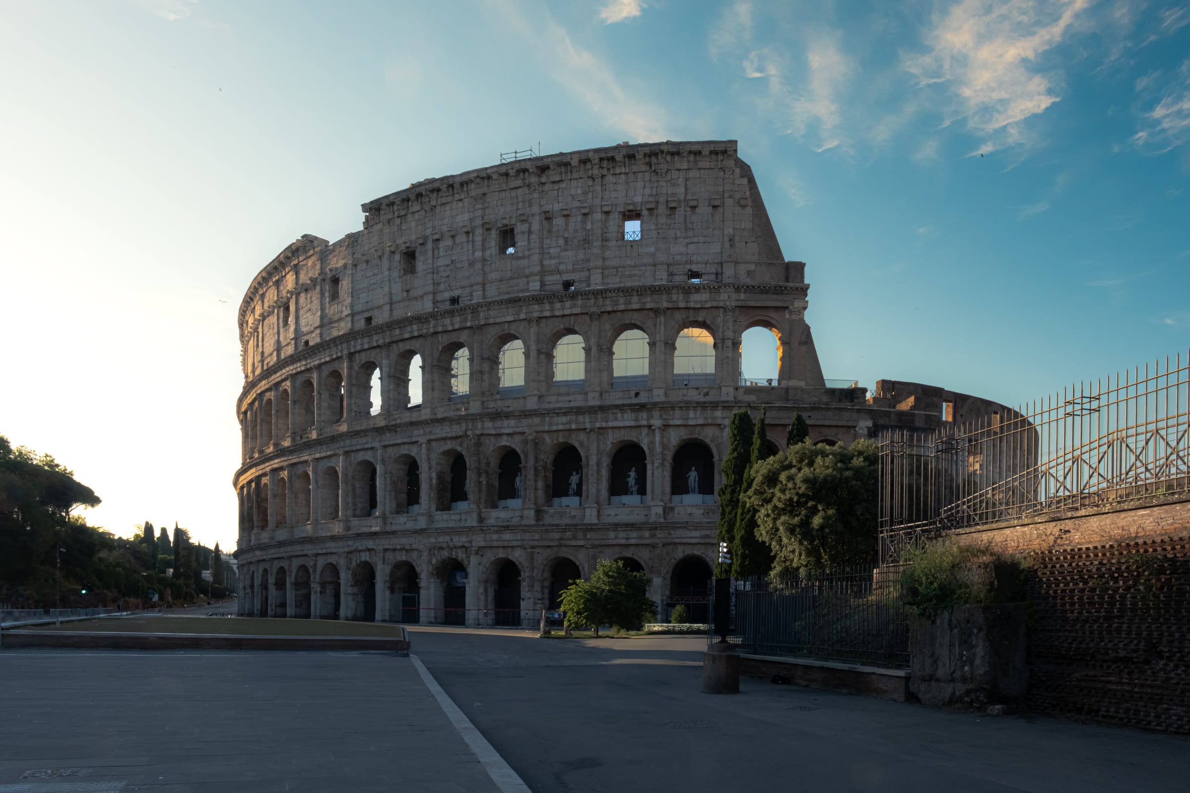 Colosseum at dawn with empty streets and golden morning light